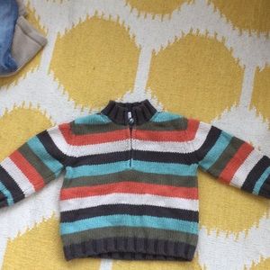 Multicolored striped half sweater with zipper.